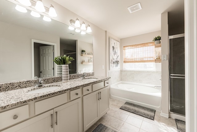 full bathroom featuring double vanity, a garden tub, visible vents, and a sink