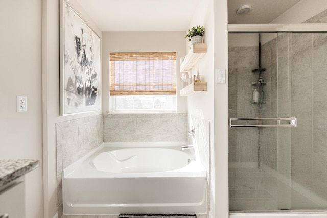 bathroom with a shower stall and a garden tub
