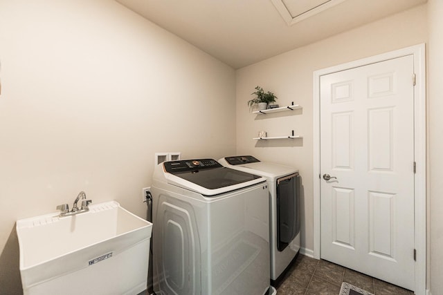 washroom featuring separate washer and dryer, laundry area, and a sink