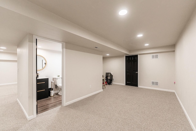 finished below grade area featuring carpet, visible vents, baseboards, and recessed lighting