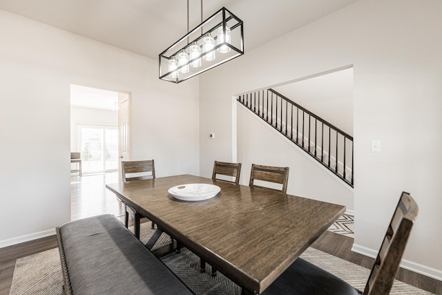 dining room featuring baseboards, stairway, and dark wood-style floors