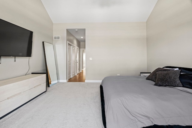 carpeted bedroom with baseboards, visible vents, and vaulted ceiling