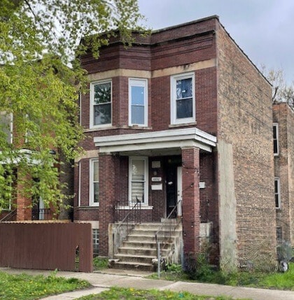 townhome / multi-family property with brick siding and fence