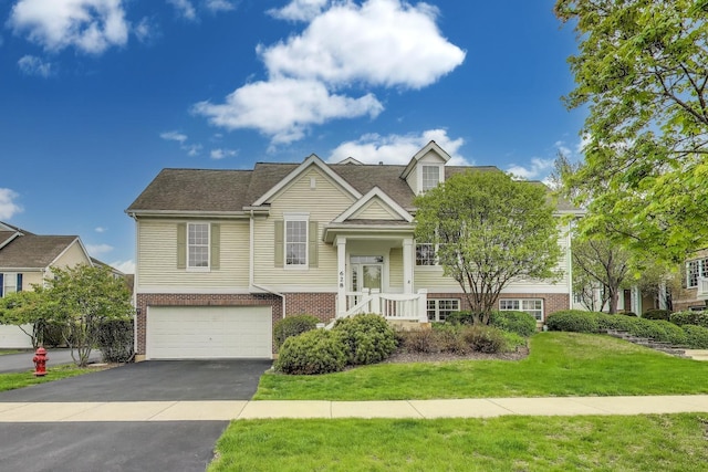 raised ranch featuring an attached garage, driveway, a front lawn, and brick siding