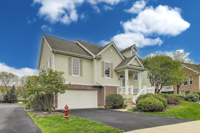 view of front of house with an attached garage, asphalt driveway, and brick siding