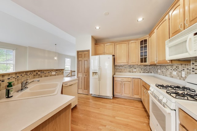 kitchen with white appliances, light brown cabinetry, light countertops, decorative backsplash, and glass insert cabinets