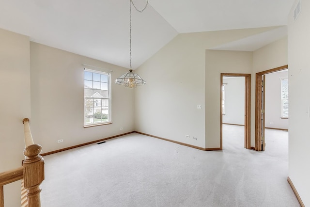 carpeted empty room featuring lofted ceiling, a chandelier, and baseboards