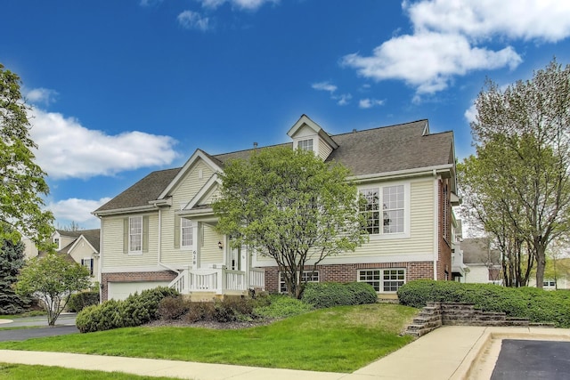 view of front of property with a front lawn, a shingled roof, and brick siding