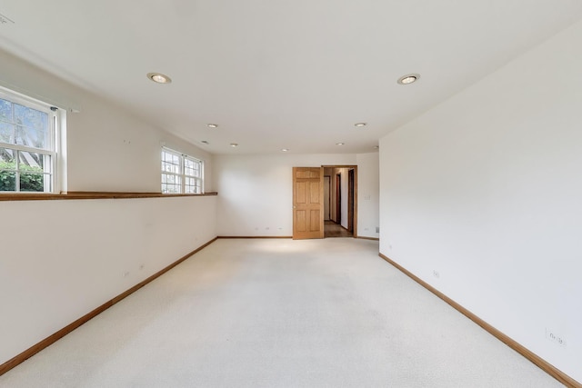 empty room featuring baseboards, recessed lighting, and light colored carpet
