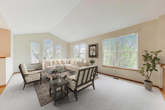 carpeted living area with vaulted ceiling and baseboards