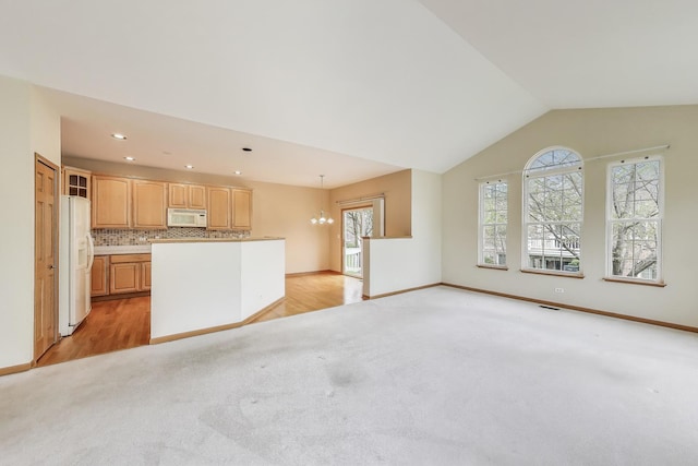 unfurnished living room with light carpet, vaulted ceiling, baseboards, and recessed lighting