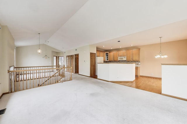 unfurnished living room with light colored carpet, baseboards, lofted ceiling, and a chandelier