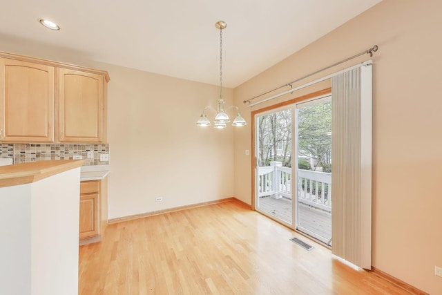 unfurnished dining area with light wood-style floors, a chandelier, baseboards, and recessed lighting