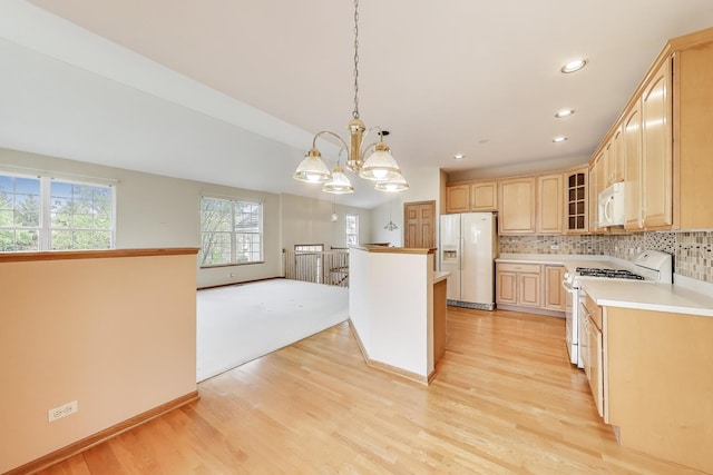 kitchen featuring white appliances, light brown cabinets, glass insert cabinets, light countertops, and tasteful backsplash
