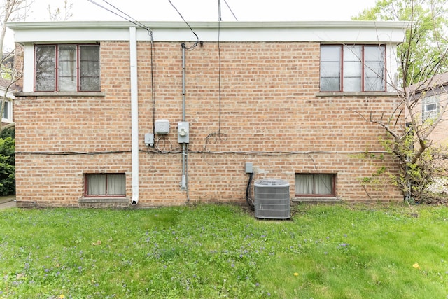 14535 University Ave, Dolton, IL 60419 - view of home's exterior featuring central AC, brick siding, and a lawn