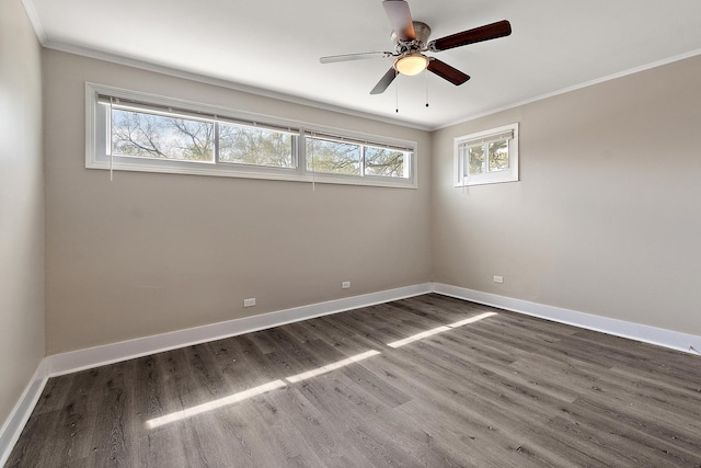 spare room with baseboards, ornamental molding, and dark wood finished floors