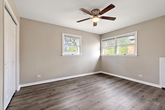 unfurnished bedroom featuring baseboards, dark wood finished floors, and a closet