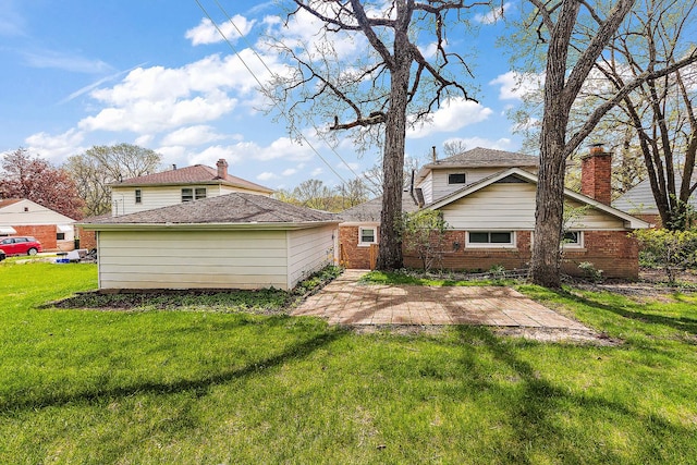 rear view of property featuring a lawn, a patio area, and brick siding