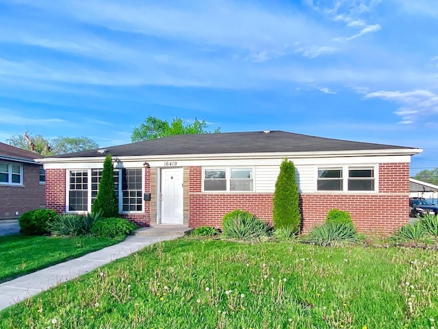 view of front of home featuring brick siding and a front lawn