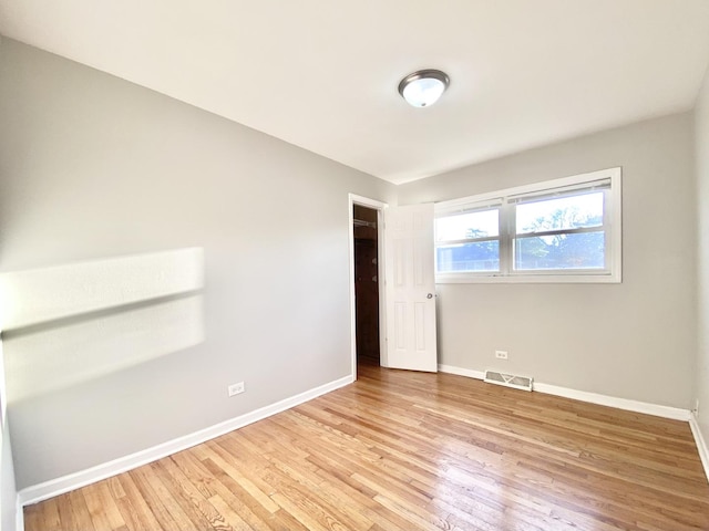 unfurnished bedroom featuring baseboards, light wood finished floors, and visible vents