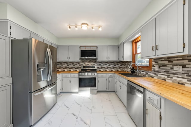 2810 Billie Limacher Ln, Plainfield, IL 60586 - kitchen featuring appliances with stainless steel finishes, a sink, light marble finish floors, butcher block counters, and decorative backsplash
