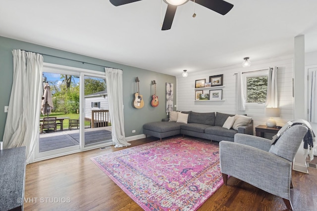 living area with ceiling fan, wood finished floors, and baseboards