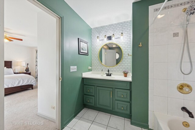 ensuite bathroom with a ceiling fan, shower / tub combination, vanity, tile patterned floors, and baseboards