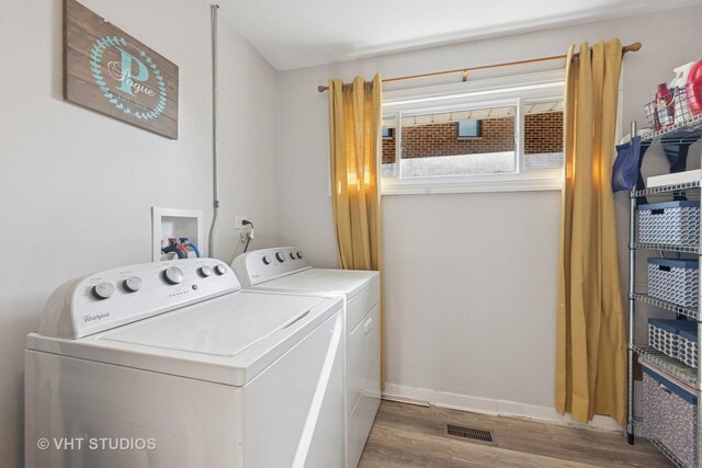 laundry area with independent washer and dryer, wood finished floors, and baseboards