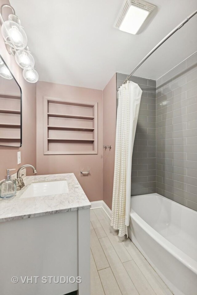 bathroom with shower / bath combo, vanity, baseboards, and built in shelves