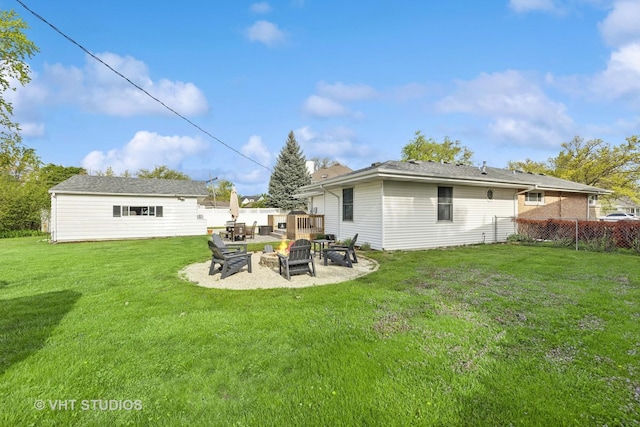 rear view of property with a fire pit, an outdoor structure, and a patio