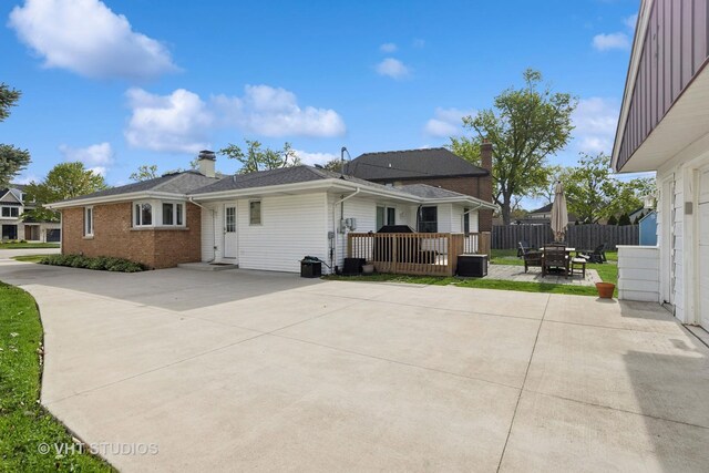 back of property featuring a patio area, fence, a chimney, brick siding, and outdoor dining space