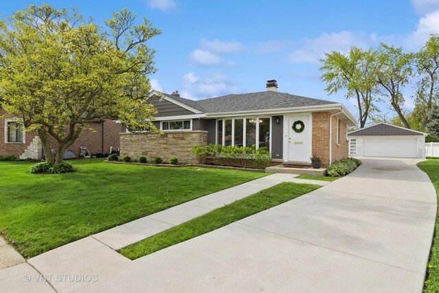 ranch-style home with an outdoor structure, a detached garage, a front yard, a chimney, and brick siding