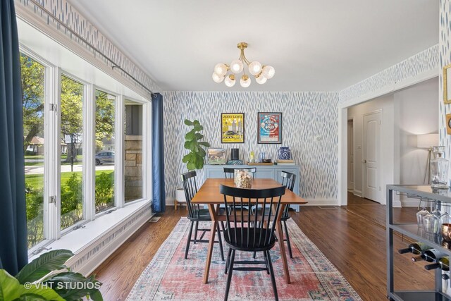 dining area featuring wallpapered walls, a chandelier, baseboards, and wood finished floors