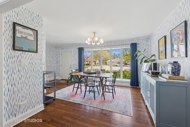 dining room with wallpapered walls, a chandelier, baseboards, and dark wood finished floors