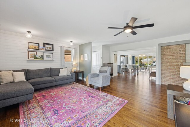 living area with a ceiling fan, wood finished floors, and plenty of natural light
