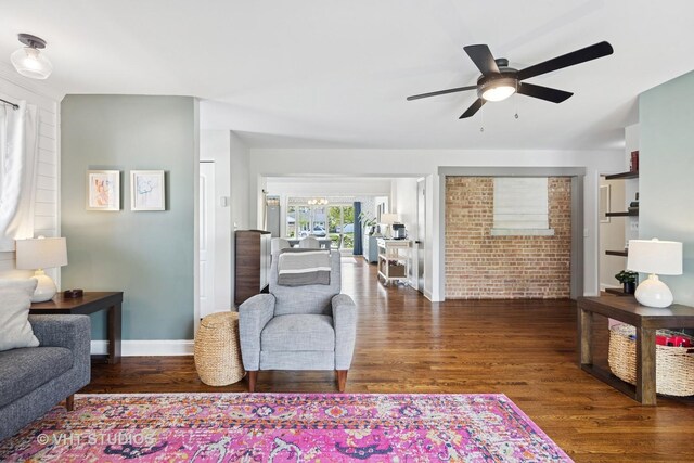 living area with a ceiling fan, wood finished floors, and baseboards