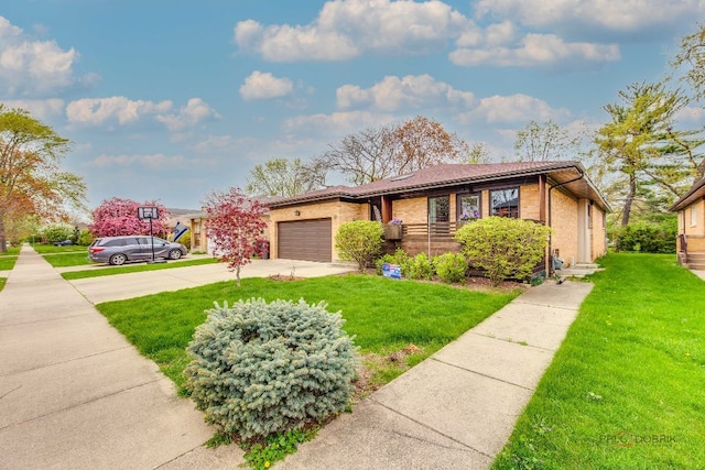 view of front of property with concrete driveway, an attached garage, a front yard, and brick siding