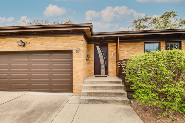 view of front of home featuring driveway, brick siding, and an attached garage
