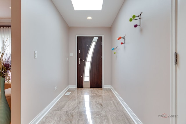 foyer featuring light marble finish flooring, a skylight, baseboards, and recessed lighting