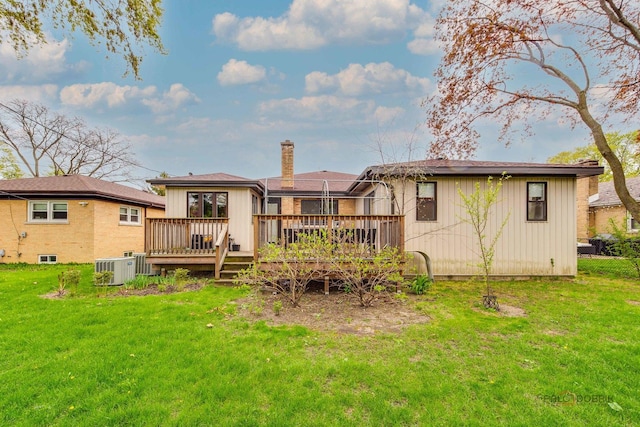 rear view of property featuring a deck, a lawn, board and batten siding, and a chimney