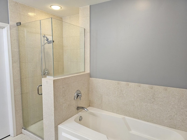 bathroom featuring a stall shower and a bath