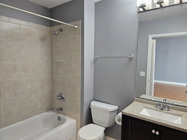 bathroom with vanity, toilet, shower / tub combination, and baseboards