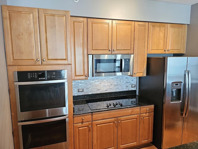 kitchen with tasteful backsplash, dark stone countertops, and appliances with stainless steel finishes