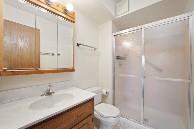 full bathroom with a stall shower, toilet, and vanity