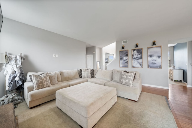 living room with baseboards, light wood-style flooring, and visible vents