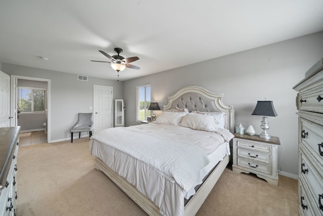 bedroom featuring visible vents, baseboards, a ceiling fan, and light carpet