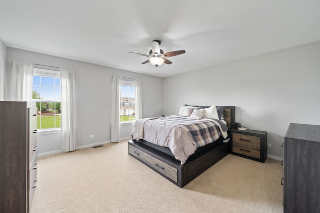 bedroom with baseboards, light carpet, and a ceiling fan