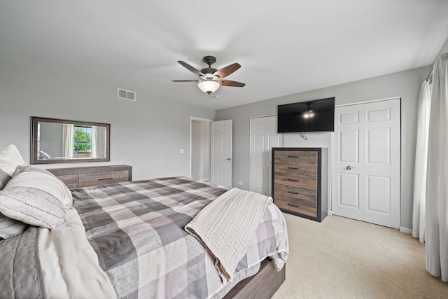 bedroom featuring ceiling fan, a closet, visible vents, and light colored carpet