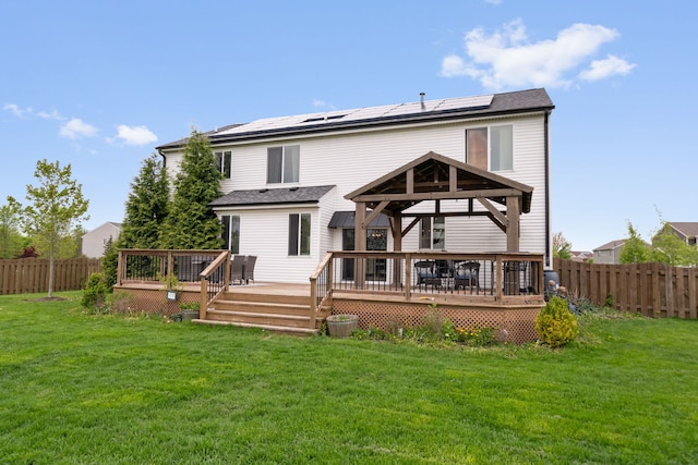 back of property featuring solar panels, a yard, a gazebo, and a fenced backyard