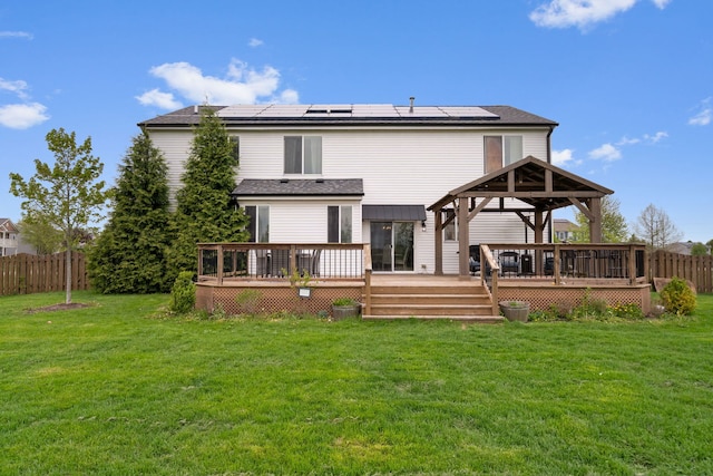 rear view of property with a yard, a gazebo, and solar panels